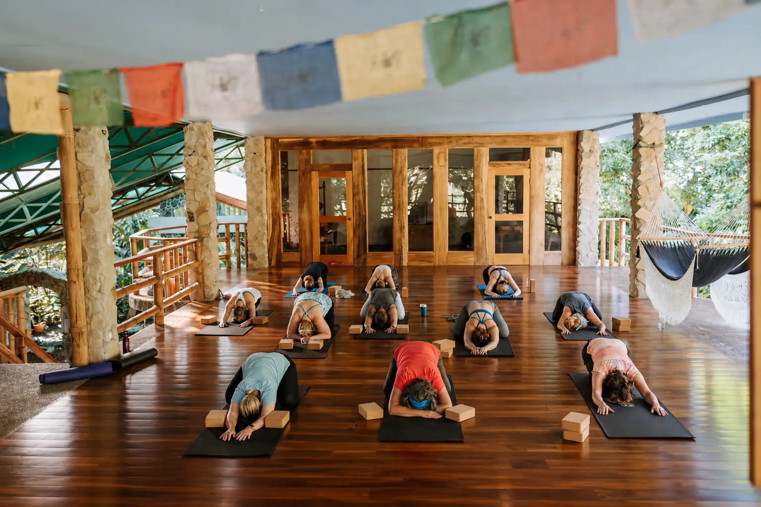 Group yoga class under prayer flags at Posada Natura